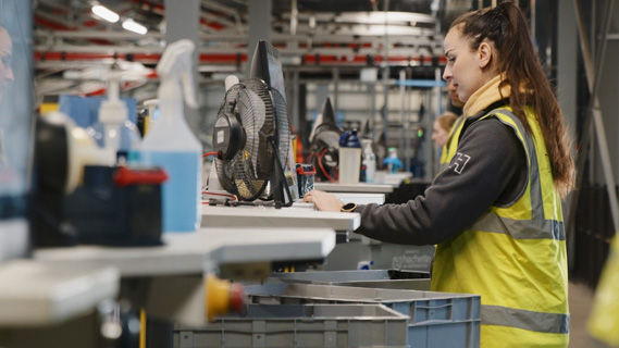 Hachette employee operating a TGW pickstation in the distribution center