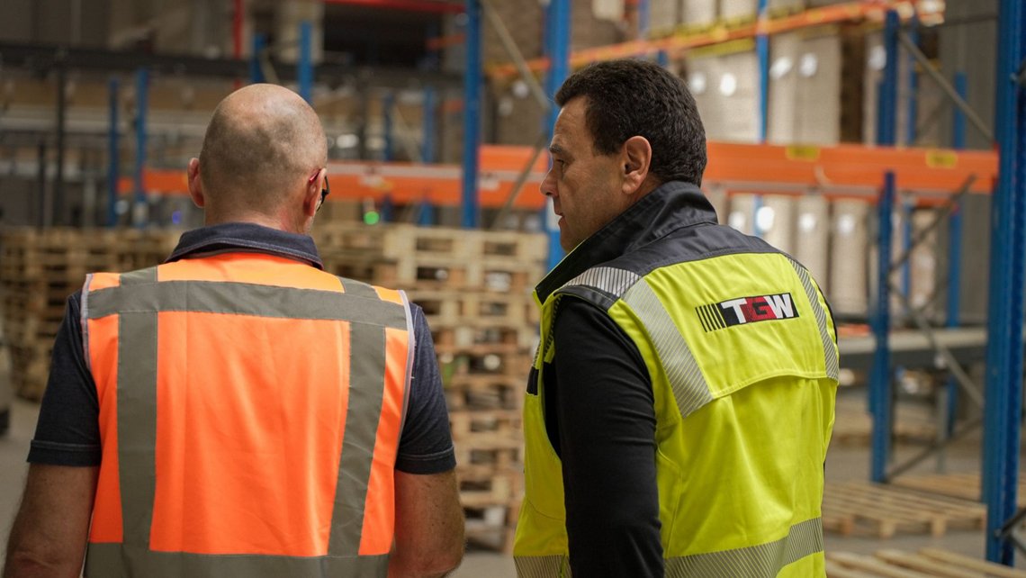 Two working man having a conversation inside the Dassy warehouse
