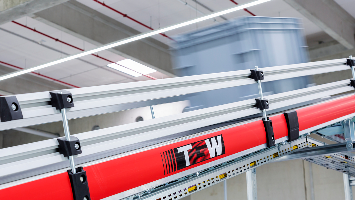 Tote going down a TGW Logistics' conveyor system, angled downward