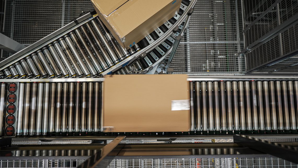 A cardboard box travelling down a conveyor belt