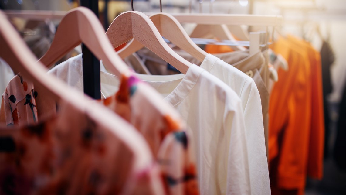 Clothes hang on hangers in a fashion store