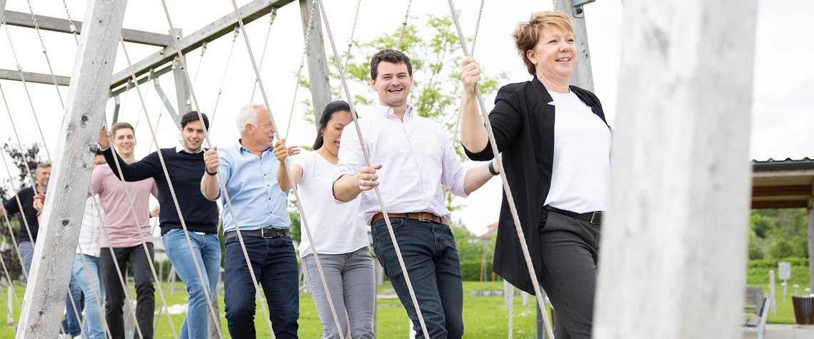 TGW Logistics employees playing on the swings in the activity garden in Marchtrenk, Austria