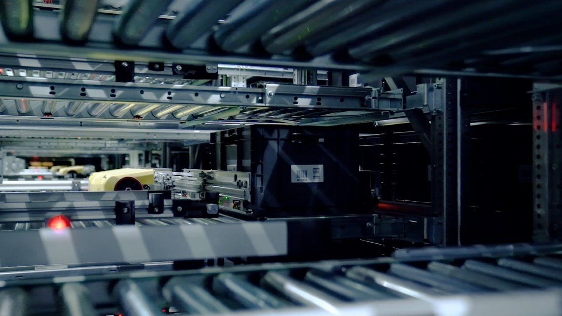 TGW Logistics' Stingray shuttle grabbing a tote out of the shuttle aisle