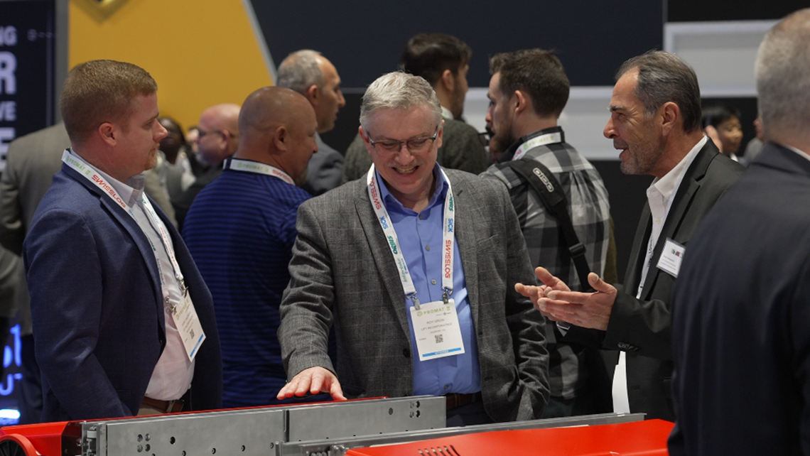 Photo of TGW Logistics employee talking to customers at a major tradeshow