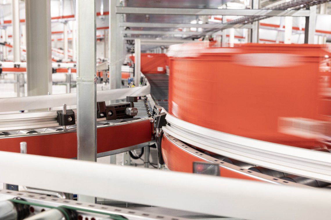 Tote travelling on a conveyor installed by TGW Logistics on-site at Picnic