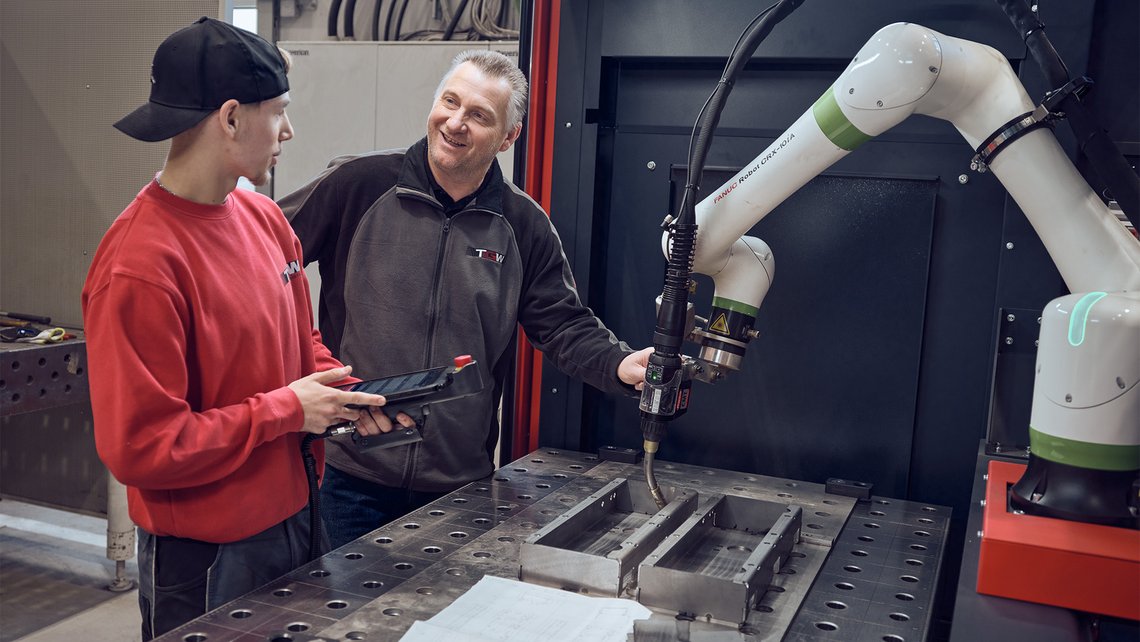 Young TGW Logistics apprentice being shown all the possibilities of the Rovoflex by a TGW expert
