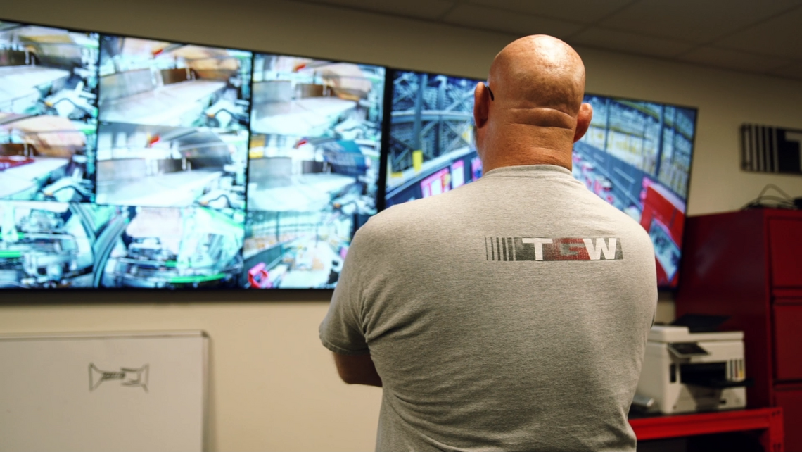 TGW Logistics Lifetime Services on-site team member inspecting screens showing the current performance of the warehouse automation solution