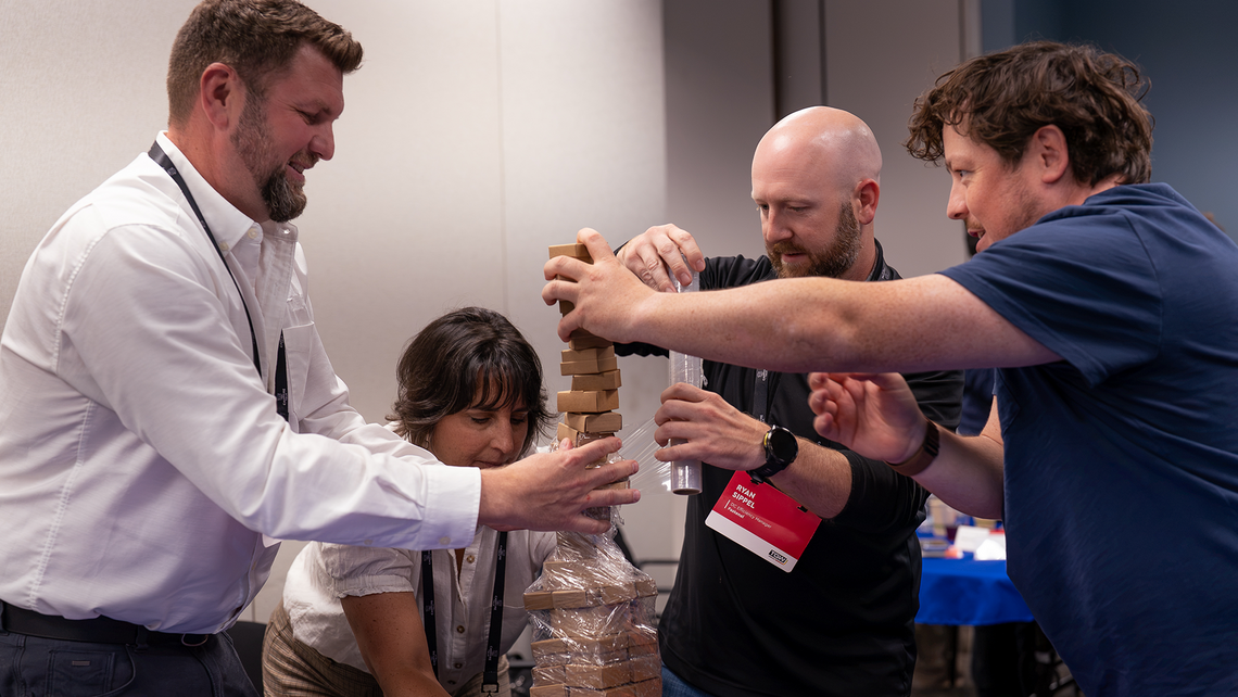 Campfire Talk attendees working together on a mini pallet build game