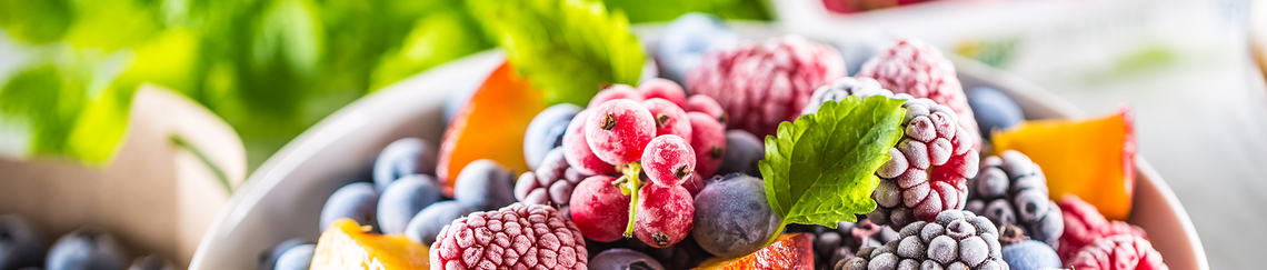 Close up of a bowl of frozen fruit and other containers of fruits that require strong cold chain logistics