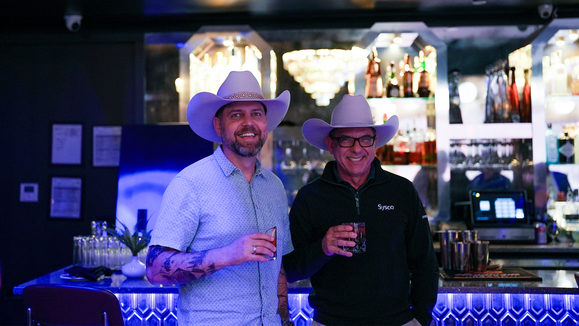 Campfire Talk attendees hanging out at the bar of a private lounge with live entertainment