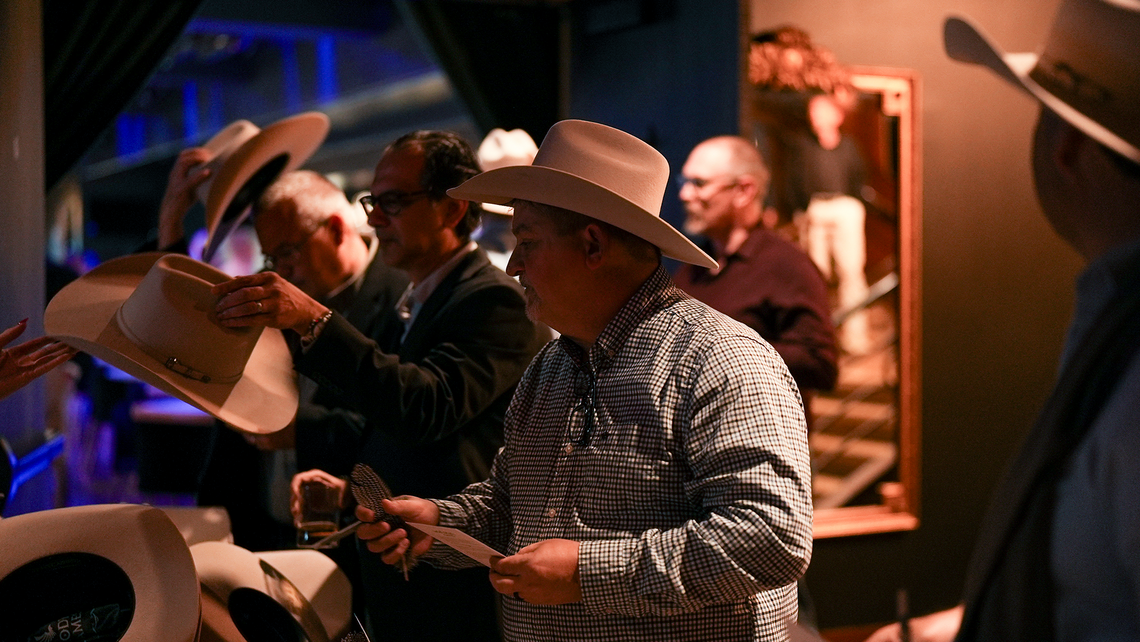 Campfire Talk attendees lining up and picking out their cowboy hat and customization