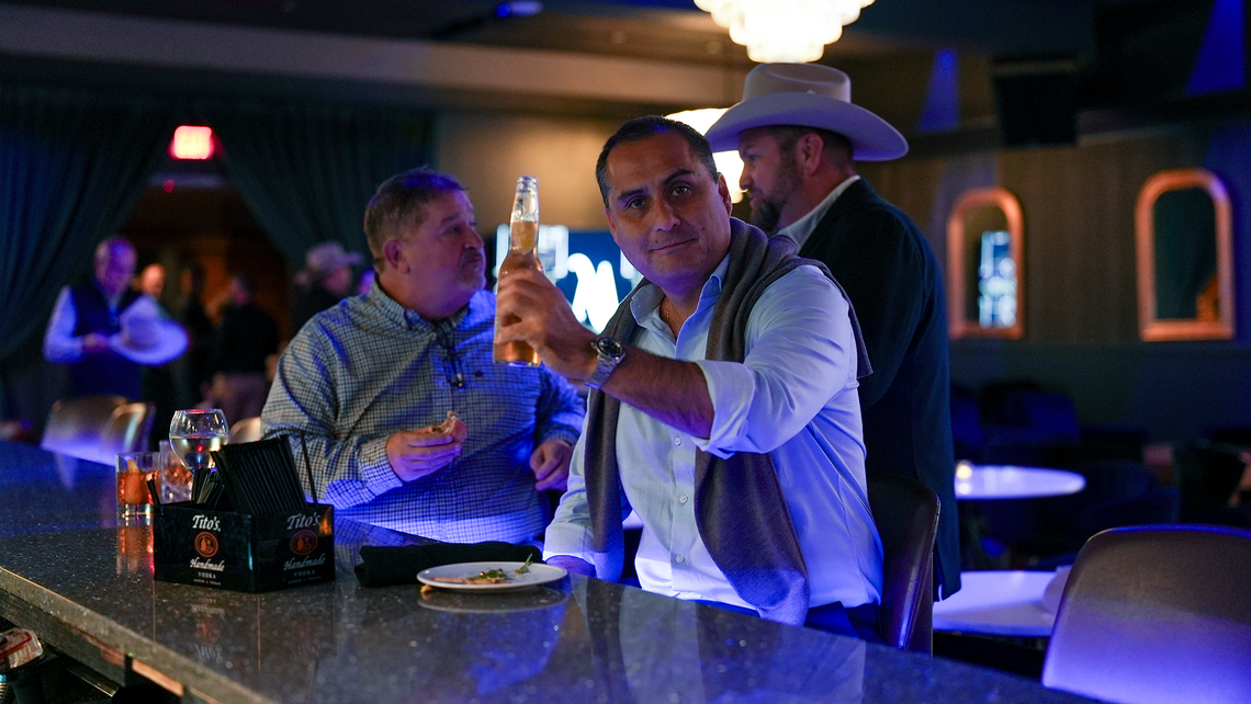 Campfire Talk attendees hanging out at the bar of a private lounge with live entertainment