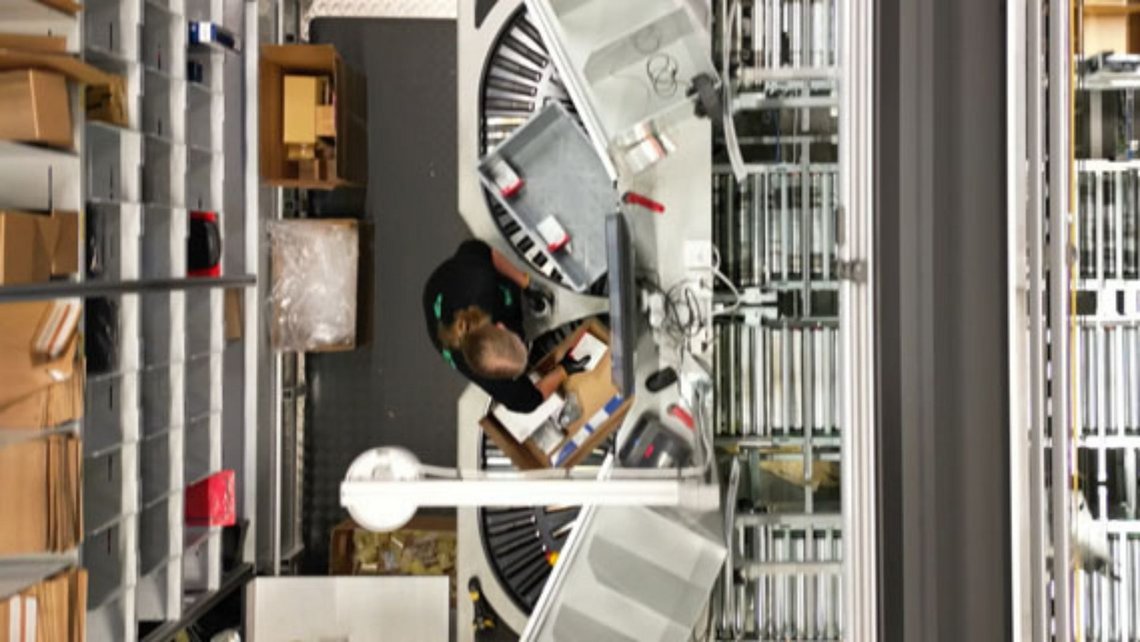 View from above of a Woman operating a picking station at the Bileko Car Parts warehouse