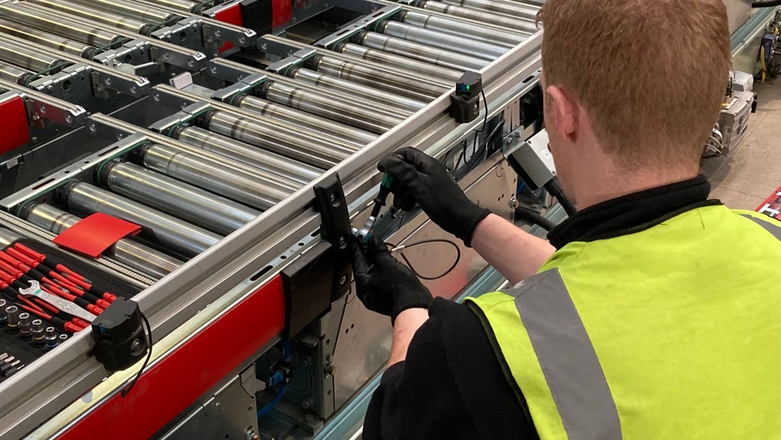 [Translate to Italy:] A logistics engineer working on an intralogistics system